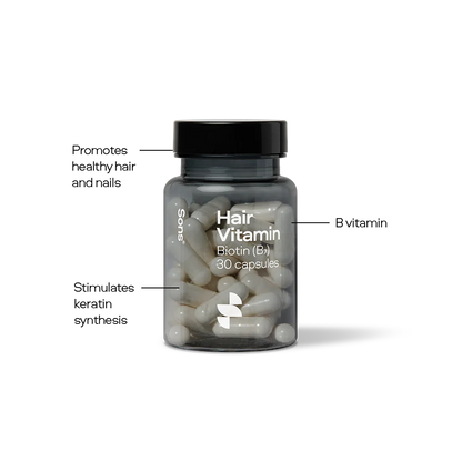 Hair vitamin supplement bottle with labeled benefits on a white background