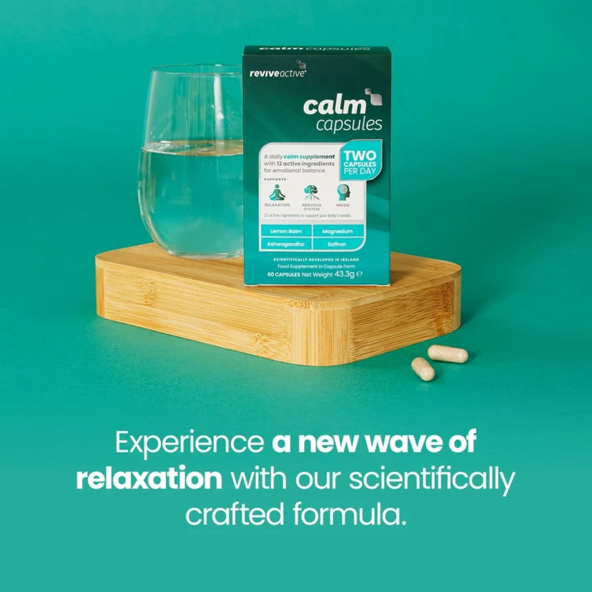 Revive Active Calm Capsules product box displayed on a wooden block next to a glass of water, with two capsules on a teal background and promotional text below.