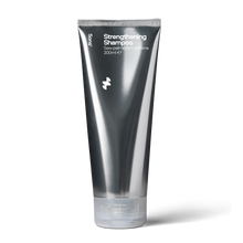 Deep silver grey tube of Sons Strengthening Shampoo on a white background.