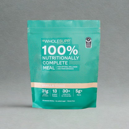 A stand-up pouch of Wholesupp 100% Nutritionally Complete Meal in Vanilla Shake flavour, featuring a teal and green design with white text on a neutral gray background. Contains 31g plant protein.