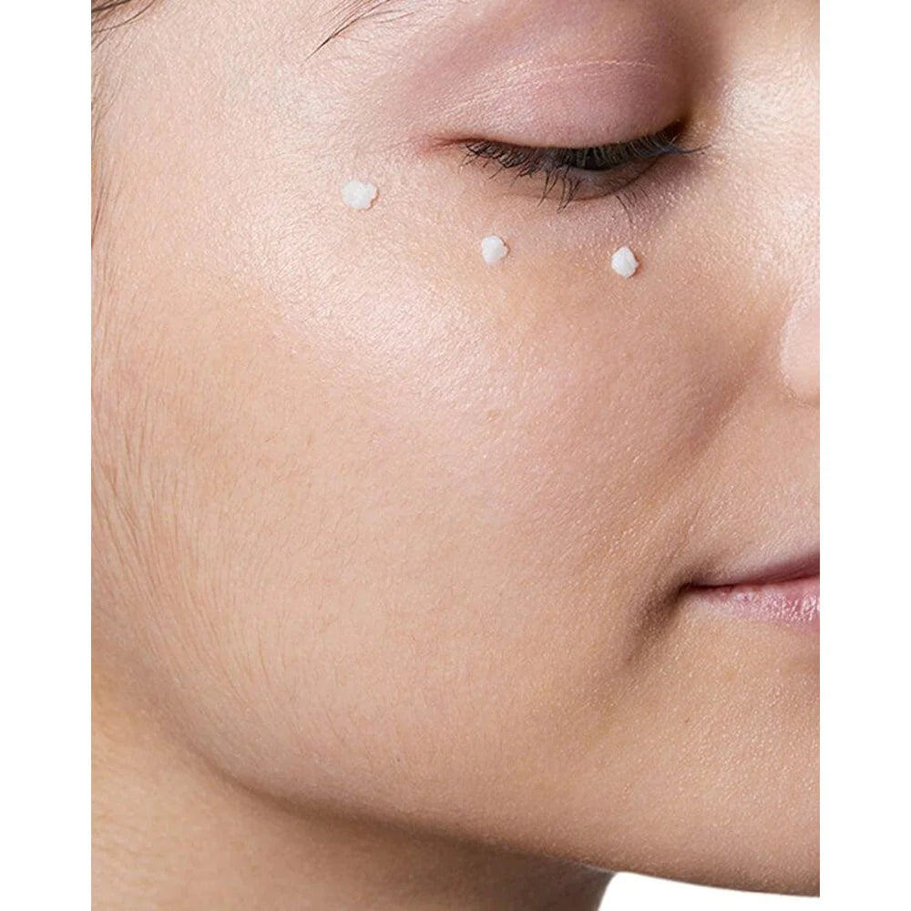 Image of white eye cream placed in three dots below the eye.