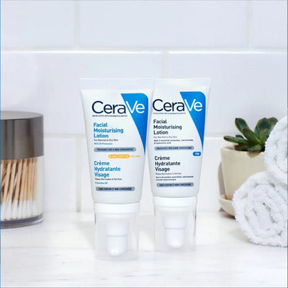 Image showing CeraVe AM moisturizer lotion with broad spectrum UVA/UVB protection, standing upright beside CeraVe PM Facial moisturising lotion on a white bathroom countertop and scene.