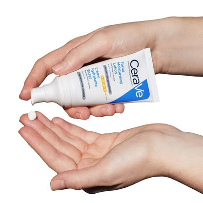 Photograph of CeraVe AM moisturizer with broad spectrum UVA/UVB protection, continuous hydration for upto 24 hours, lightweight, non-comedogenic formula, being dispensed from a pump top on a tub of lotion onto fingertips.