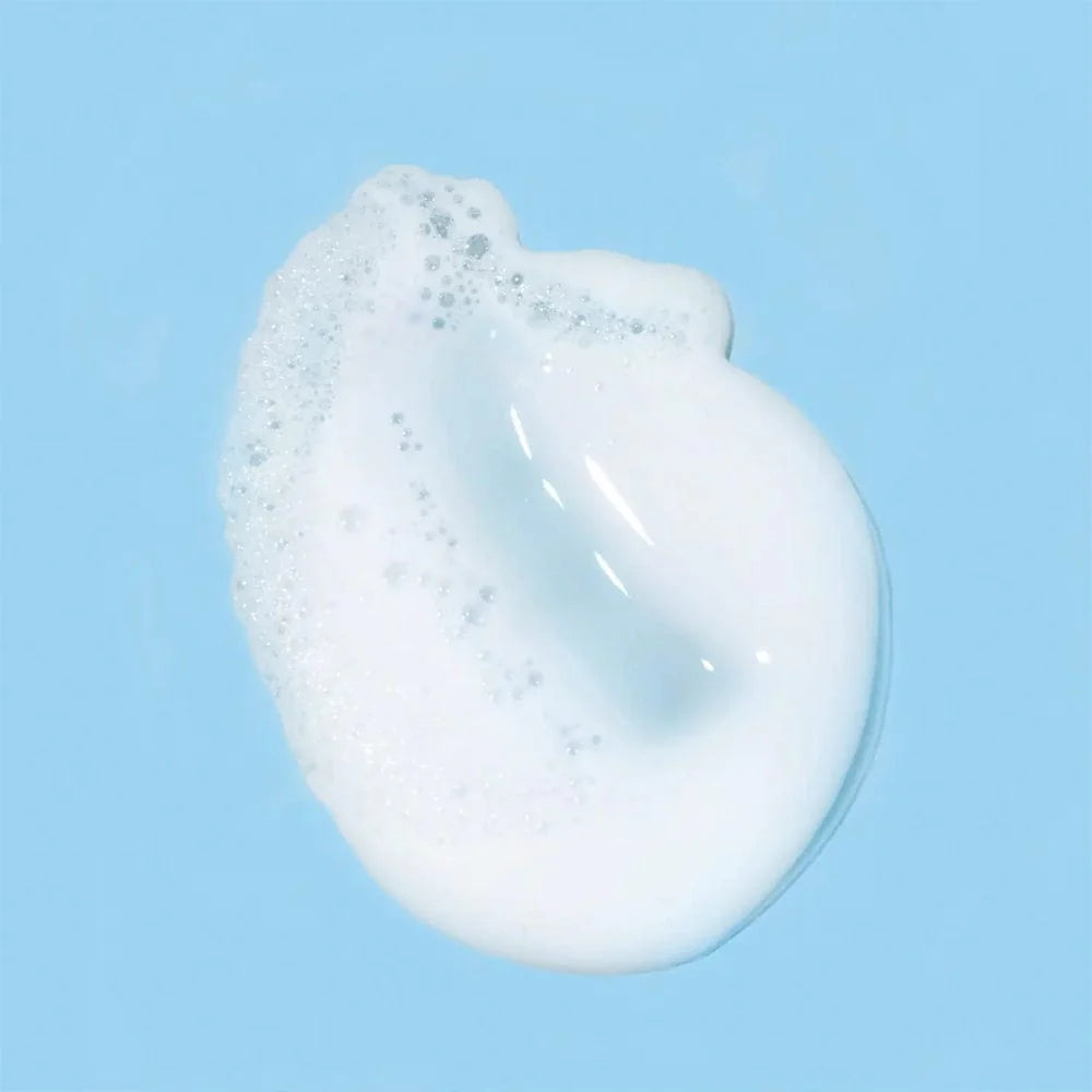 Image of a smear of foaming cream cleanser on a baby blue background
