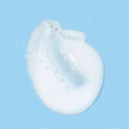 Image of a smear of foaming cream cleanser on a baby blue background