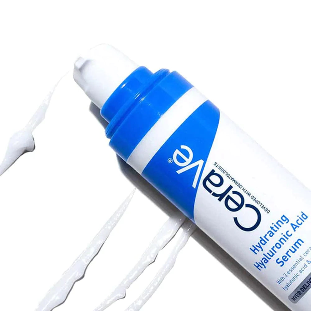 Image of blue and white cylindrical pump bottle of CeraVe Hydrating Hyaluronic Acid Serum with 3 essential ceramides and panthenol vitamin B5 emollient. With 4 stripes of serum pumped onto a white background.